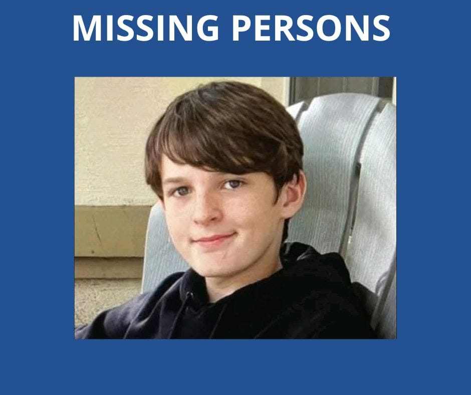 A young boy with brown hair and a black hoodie sits on a chair and smiles. Above him, large white text reads "MISSING PERSONS" on a blue background.