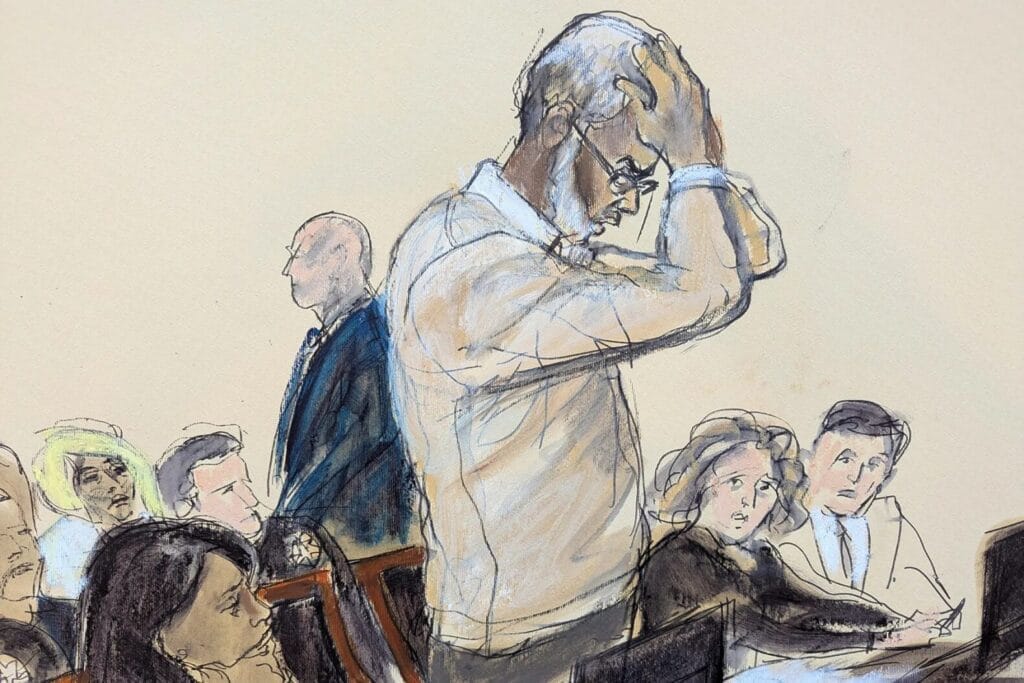 A courtroom sketch shows a man standing, holding his head in distress, while others sit and watch attentively.